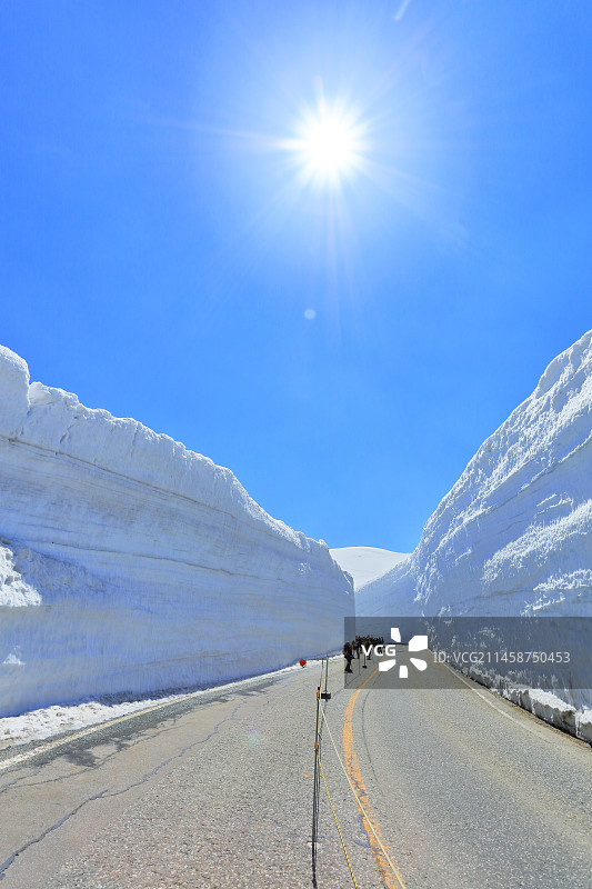 日本立山雪谷步行道和天空中的太阳，富山县图片素材