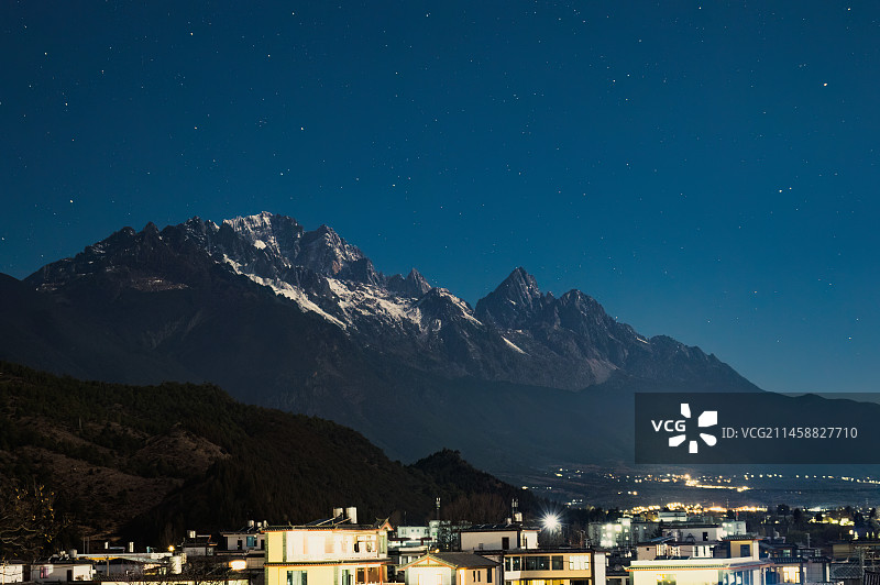 夜晚星空下的云南丽江玉龙雪山与小镇房屋图片素材