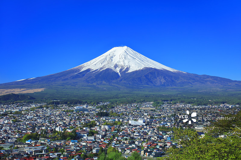 晴空下的富士山和城镇景观，日本山梨县富士吉田市图片素材