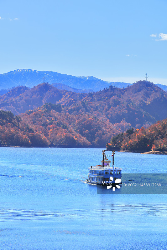 日本新泻县鱼沼市奥只见水坝、观光船和雪山山脉图片素材