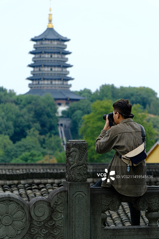 雷峰塔下拍照的摄影师图片素材