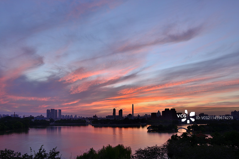 夕阳下的晚霞天空映衬下的天津水上公园西湖景观图片素材