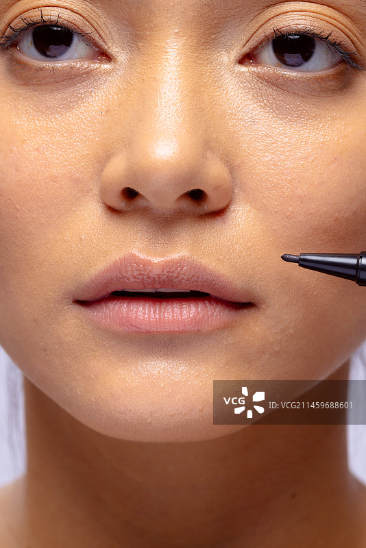 亚洲女性面部及美容外科医生黑色记号笔特写图片素材
