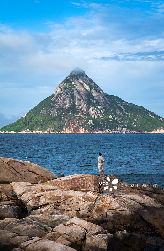 站在海边岩石上眺望远方的人图片素材