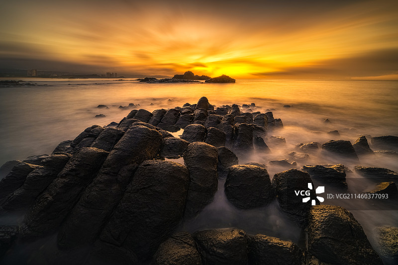 漳州古火山口日落时的海景玄武岩石对天的景色图片素材