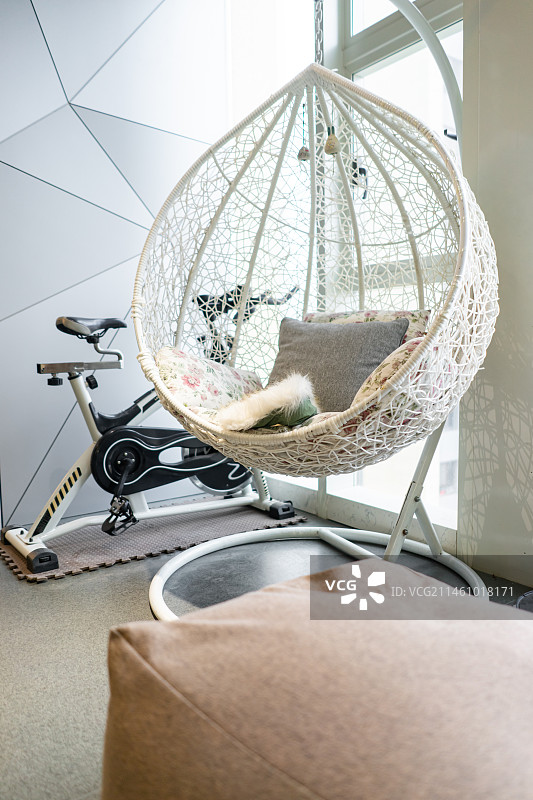 中国健康生活方式拍摄主题，阳台前面住宅房间里的悬挂的吊篮座椅和透明的玻璃，室内无人图像摄影图片素材