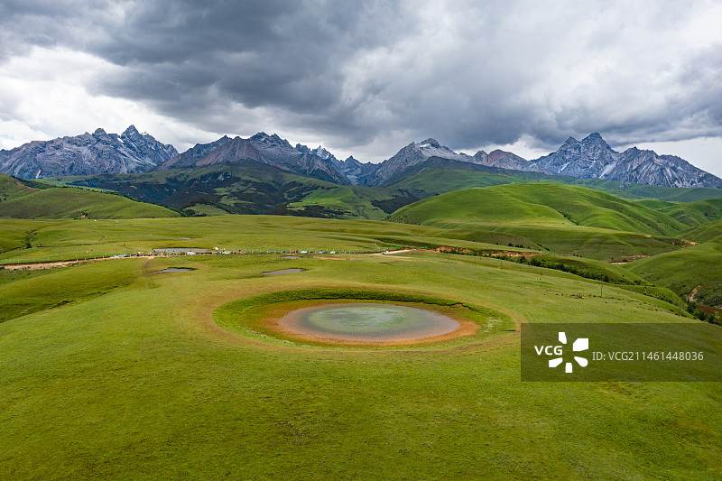 四川甘孜理塘县格聂之眼航拍，远处是格聂群峰。图片素材