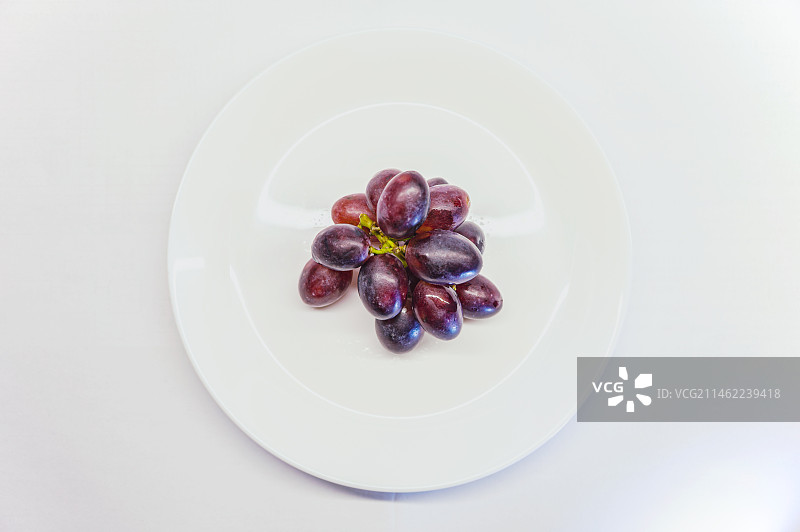 白瓷盘里的紫色葡萄图片素材