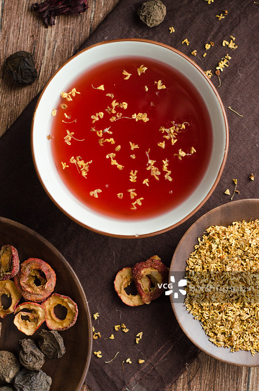 木纹桌面上的一碗撒满桂花的老北京酸梅汤图片素材