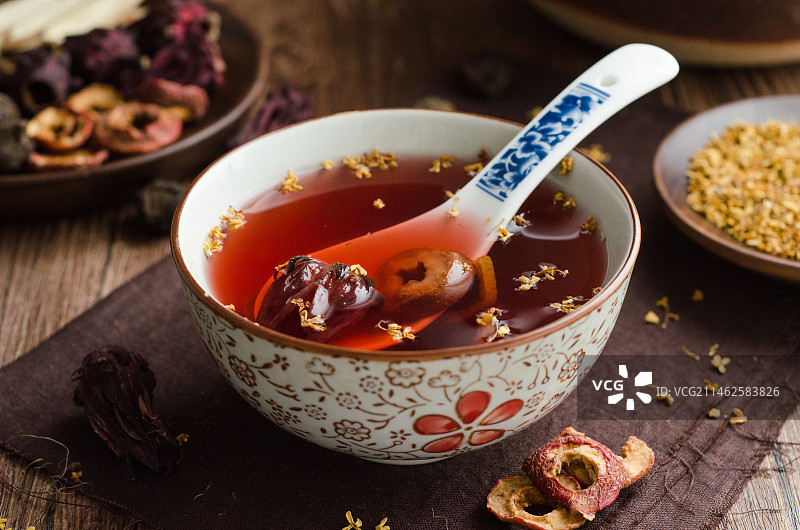 木纹桌面上的一碗撒满桂花的老北京酸梅汤图片素材