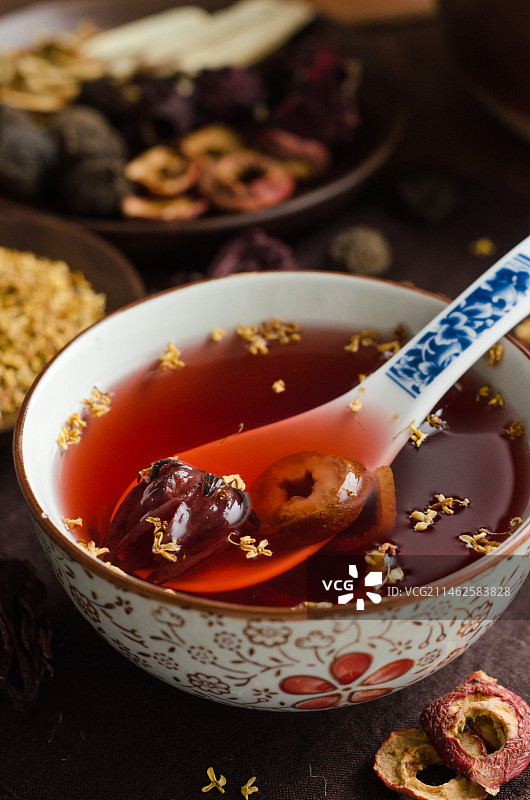 木纹桌面上的一碗撒满桂花的老北京酸梅汤图片素材