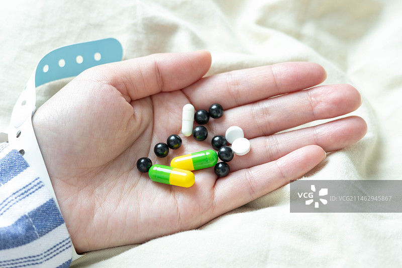 病床上的病人手捧药丸图片素材