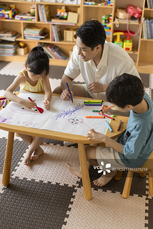Little Chinese children painting in art class with teacher图片素材