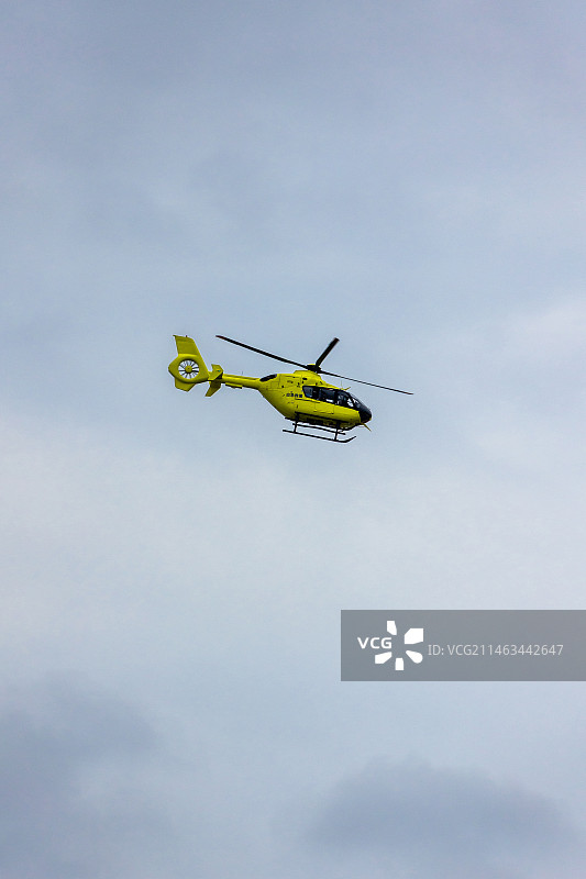 天空飞过的黄色应急救援直升机图片素材