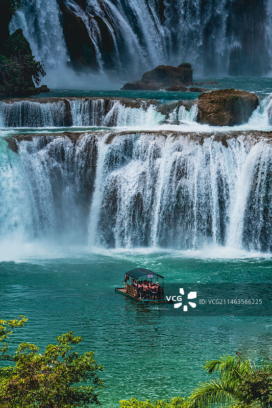 广西崇左市德天跨国瀑布下河流上的小舟图片素材