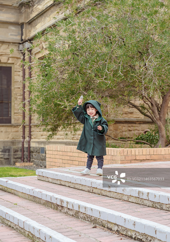 国外大学欧美建筑台阶处穿风衣男孩图片素材