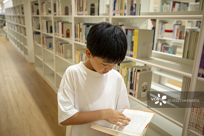 中国小男孩在图书馆看书阅读图片素材