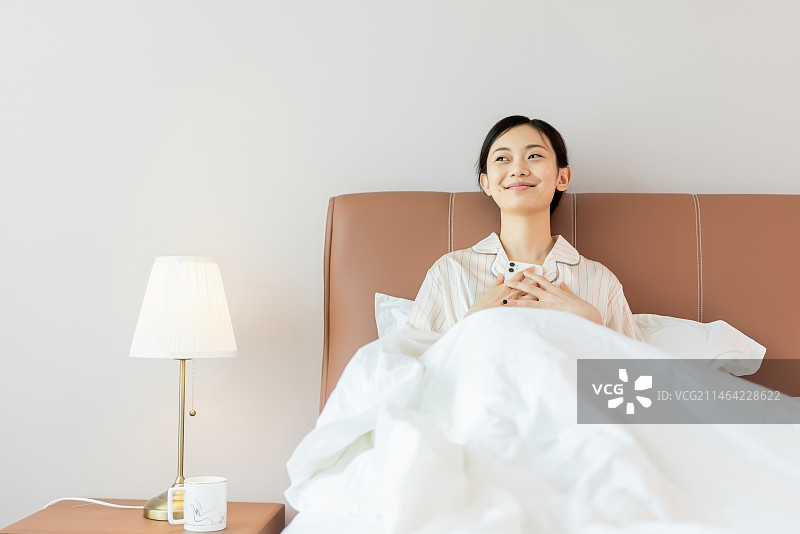 清晨女孩开心的在床上醒来图片素材