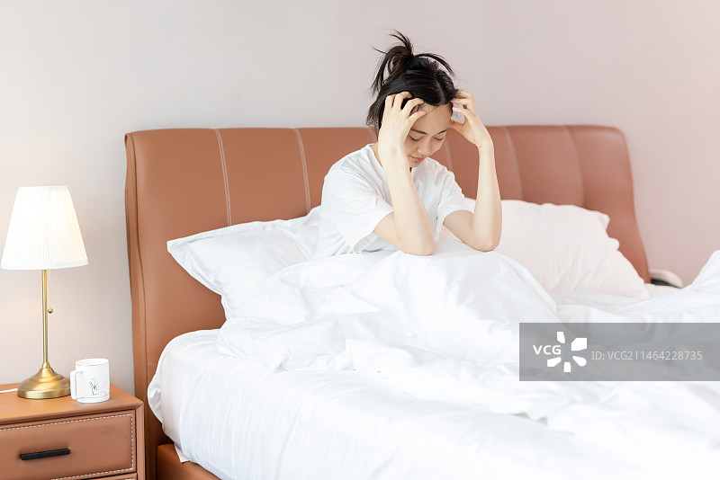 焦虑不安的女孩在床上图片素材