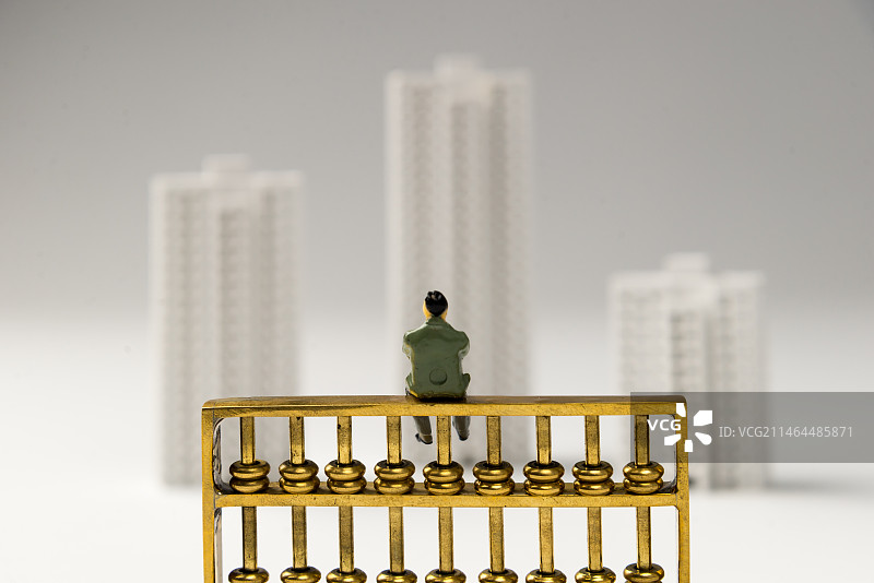 人偶坐在金算盘上 城市楼房背景图片素材