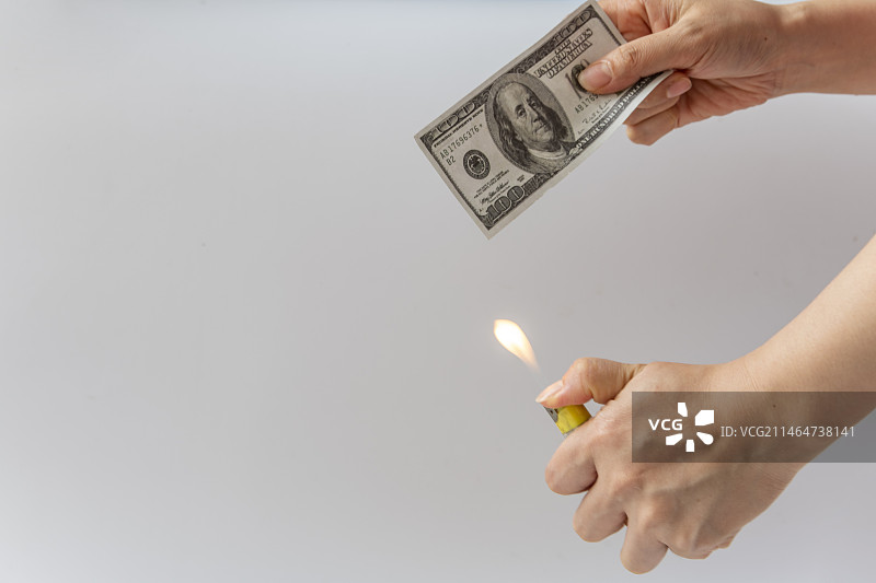 白色背景中手里拿着打火机和美元图片素材