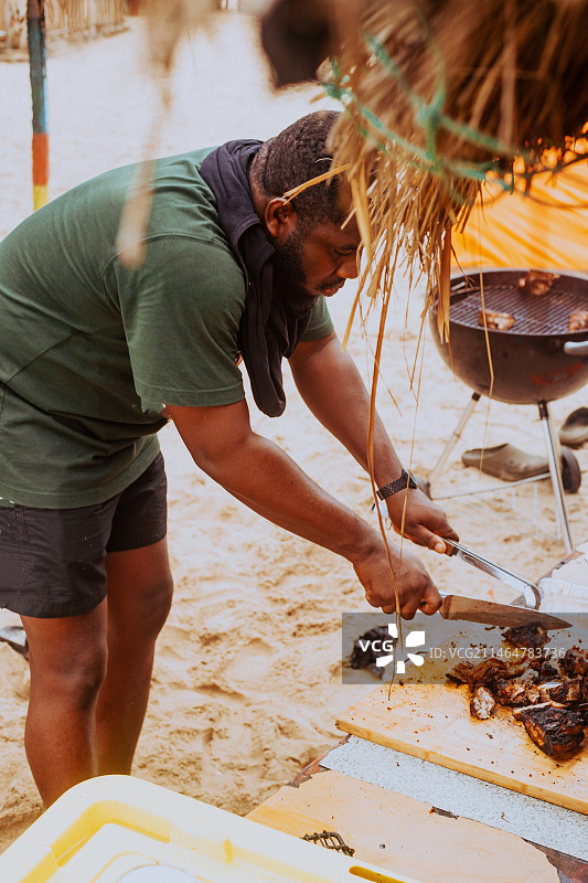 男人在加纳阿克拉海滩烧烤图片素材