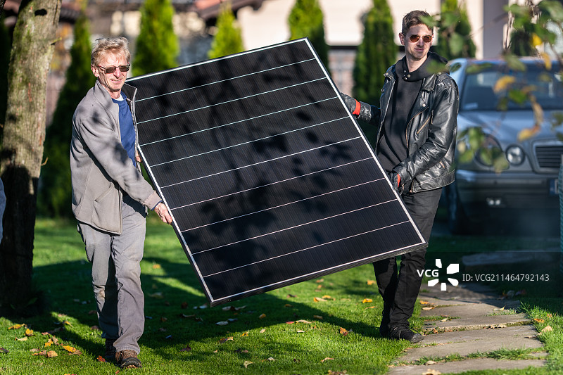 父子共同安装太阳能电池板，波兰图片素材