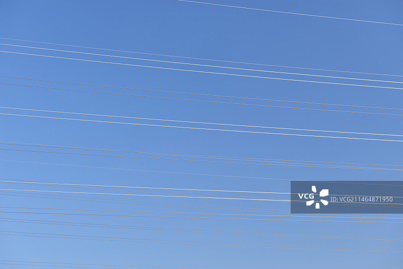 蓝天下电力线的低角度视图图片素材