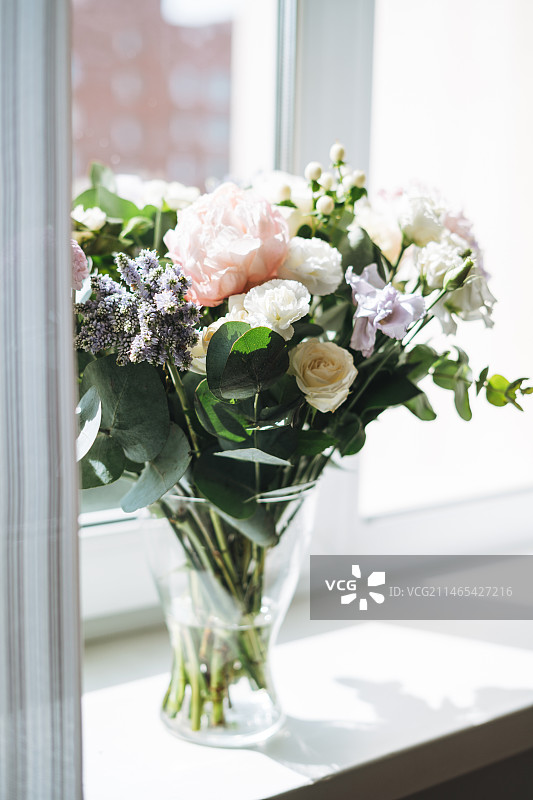 白色和粉色玫瑰、绿色植物和其他花卉花束图片素材