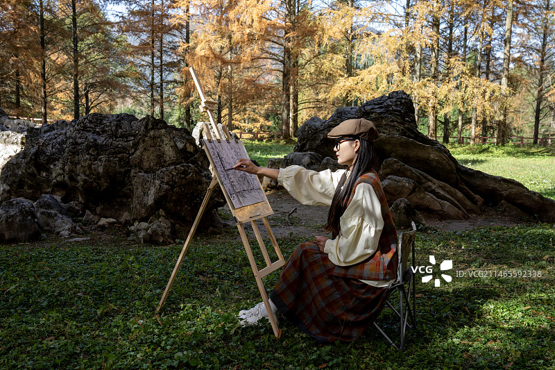 一位美女大学生在植物活化石水杉故乡湖北利川小河水杉公园写生图片素材