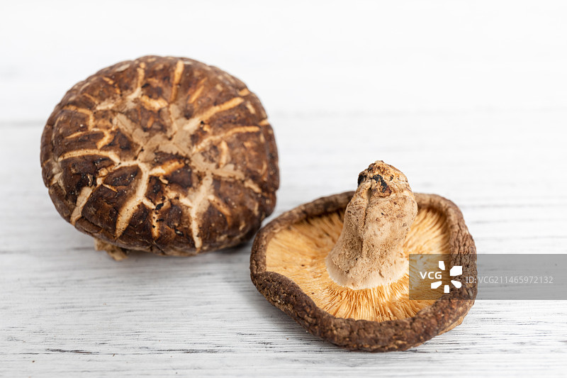 白色木纹桌面上的两朵干花菇图片素材