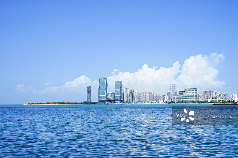 蓝天白云下的现代城市建筑与海洋图片素材