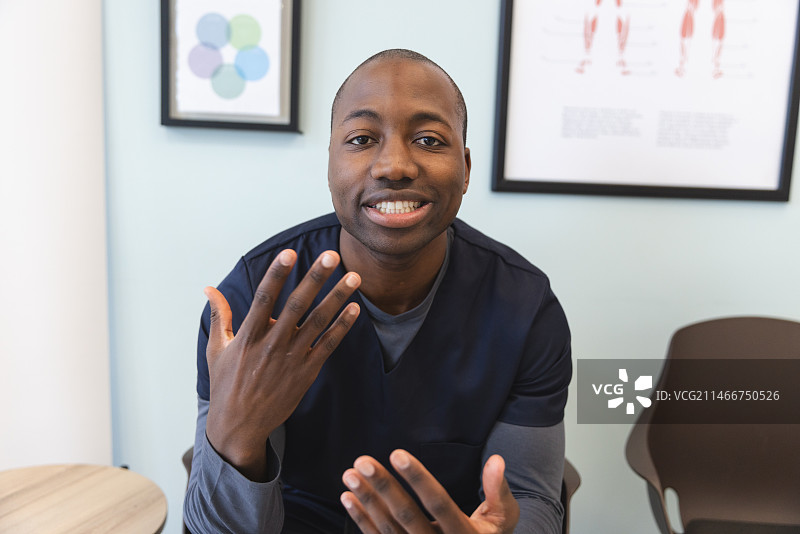 在医院候诊室进行视频通话的非裔美国男医生图片素材