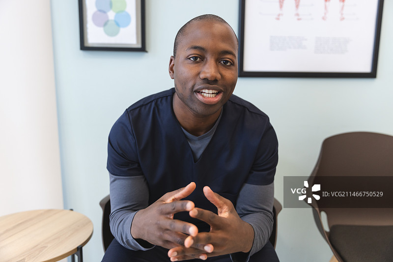 在医院候诊室进行视频通话的非裔美国男医生图片素材