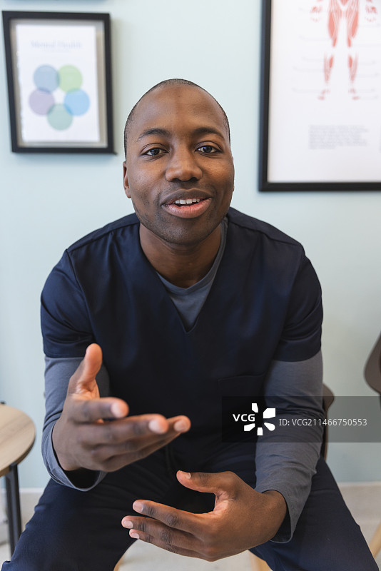 在医院候诊室进行视频通话的非裔美国男医生图片素材