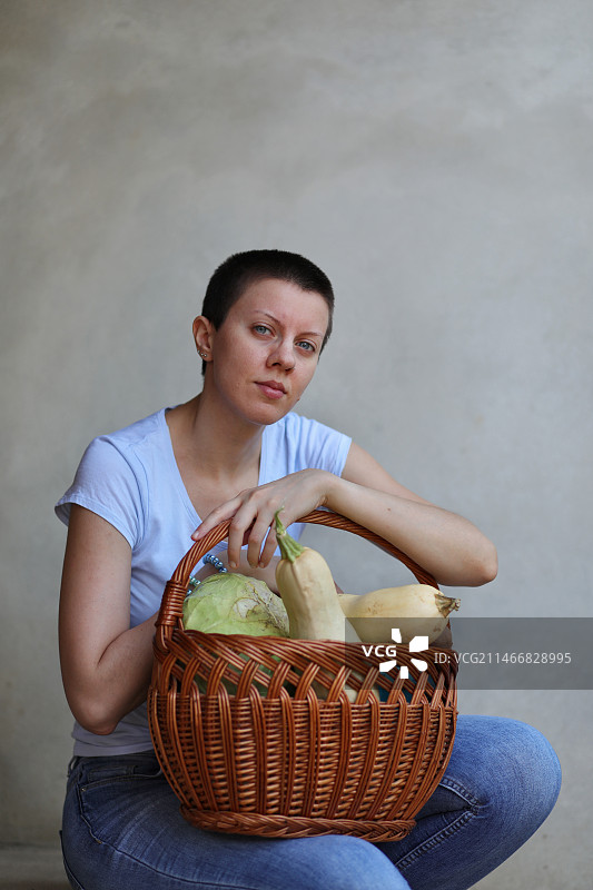 塞尔维亚：坐在墙边手持篮子的女人图片素材