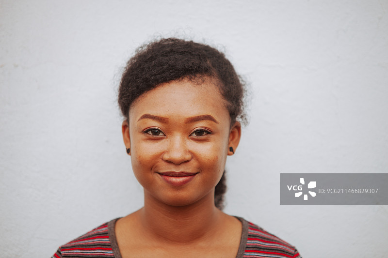 靠墙微笑的年轻女子画像图片素材