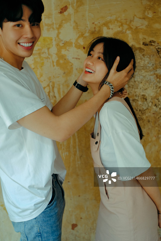 站在越南墙边的微笑年轻女子肖像图片素材