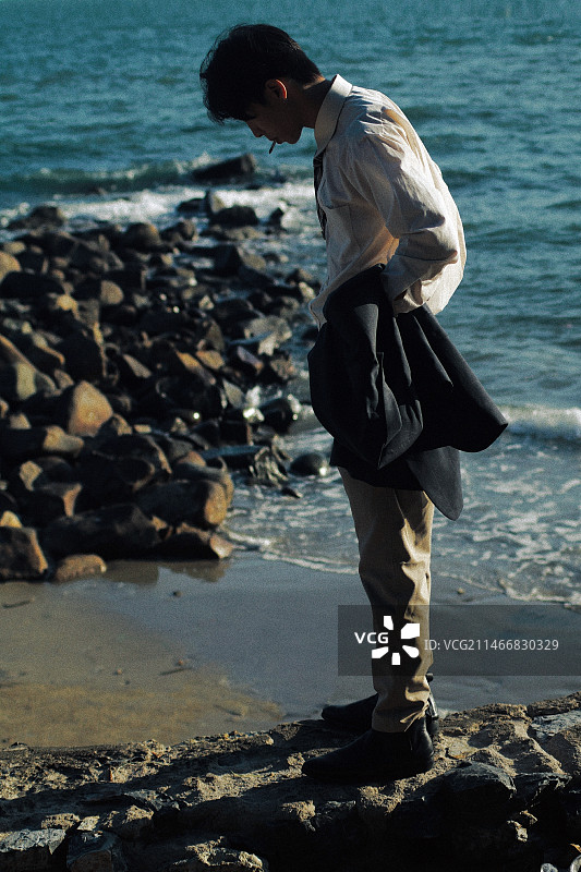 男子在越南海滩站立的侧视图图片素材