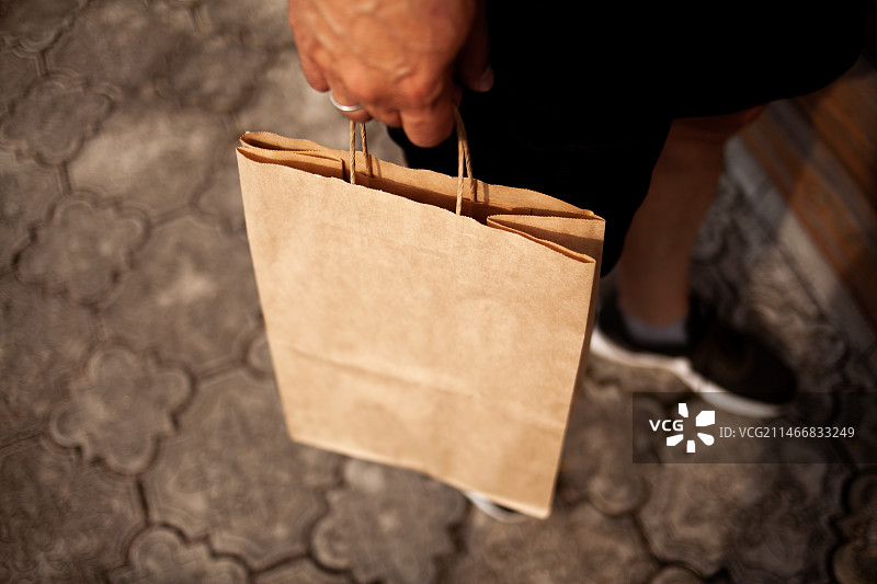 白俄罗斯：男子手提纸袋的腰部特写图片素材