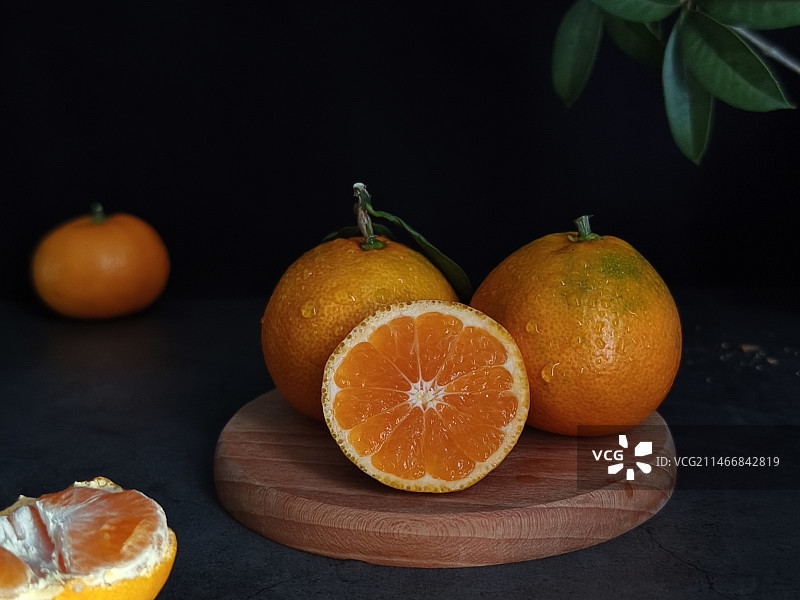 黑色背景下桌上橘子的特写镜头图片素材