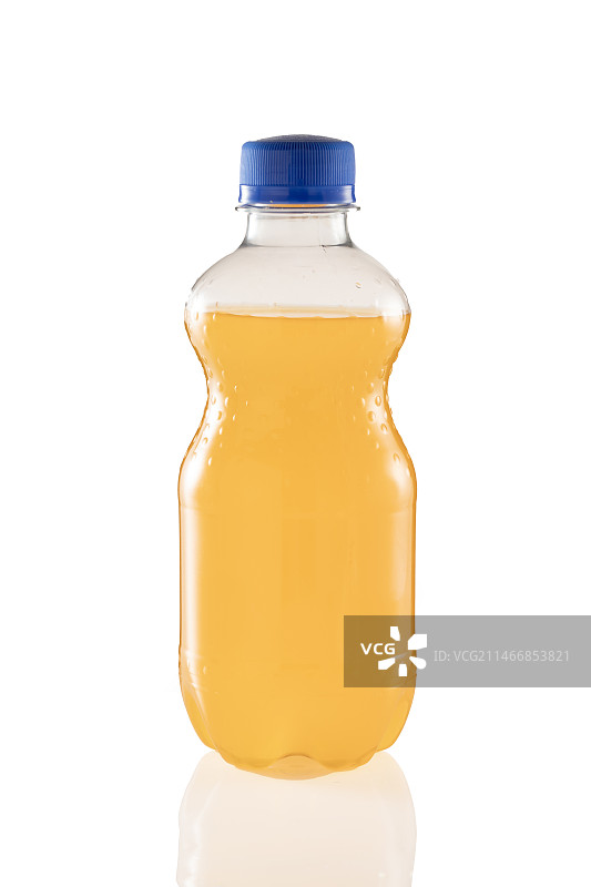 白色背景下的橙味碳酸饮料瓶子特写镜头图片素材