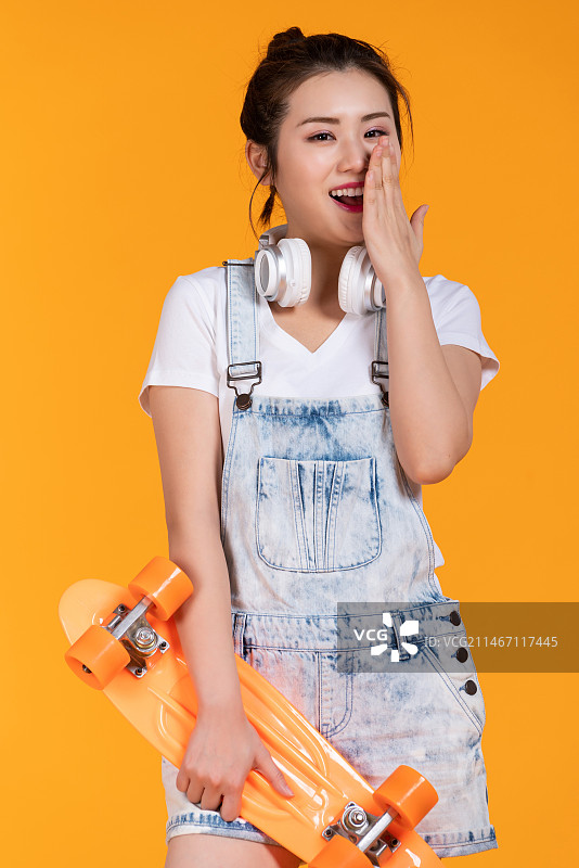 棚拍拿着滑板的年轻女子图片素材