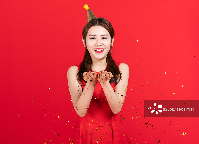 快乐的年轻女子手捧礼花图片素材