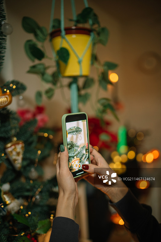 女人在西班牙用智能手机拍摄圣诞树图片素材