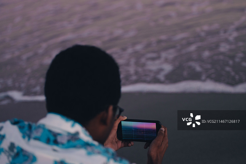 在美国白帽海滩拍照的男人背影图片素材