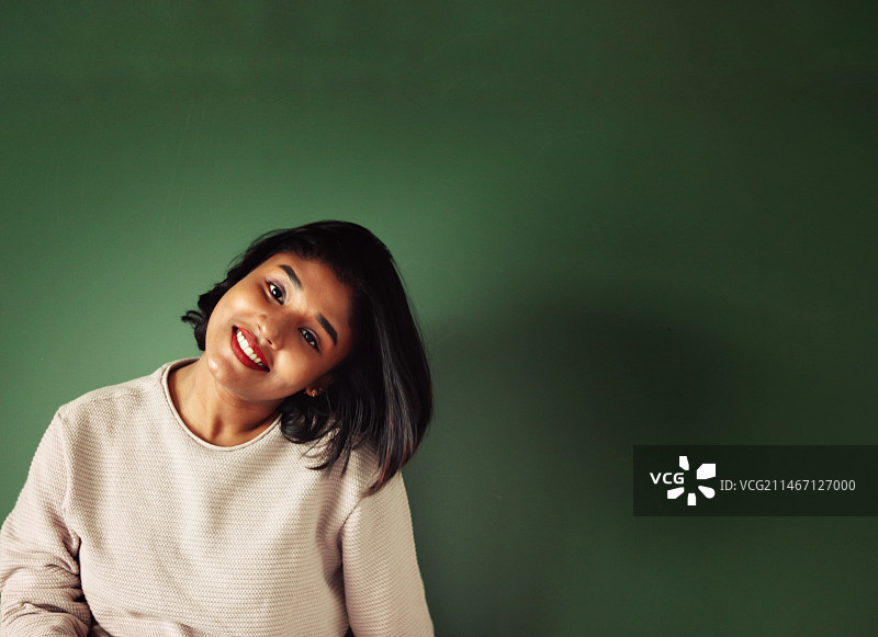 微笑的女孩靠在墙上，印度喀拉拉邦图片素材