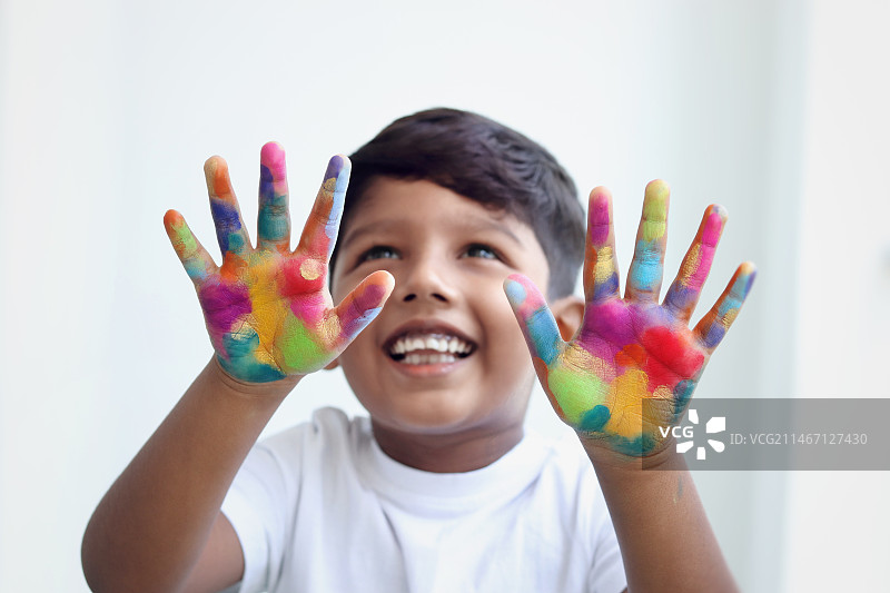 展示彩绘双手的女孩的近距离肖像图片素材