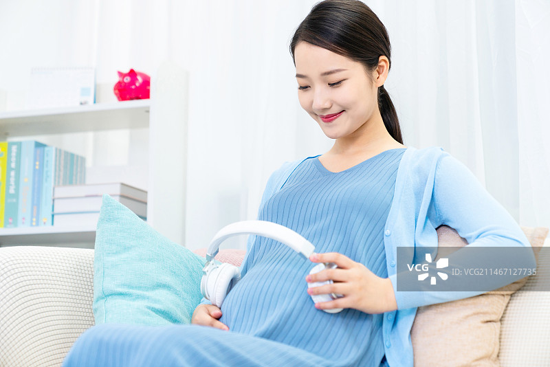孕妇把耳机放在肚子上图片素材