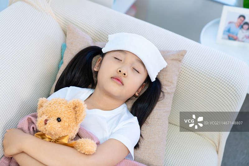 生病的小女孩躺在沙发上图片素材